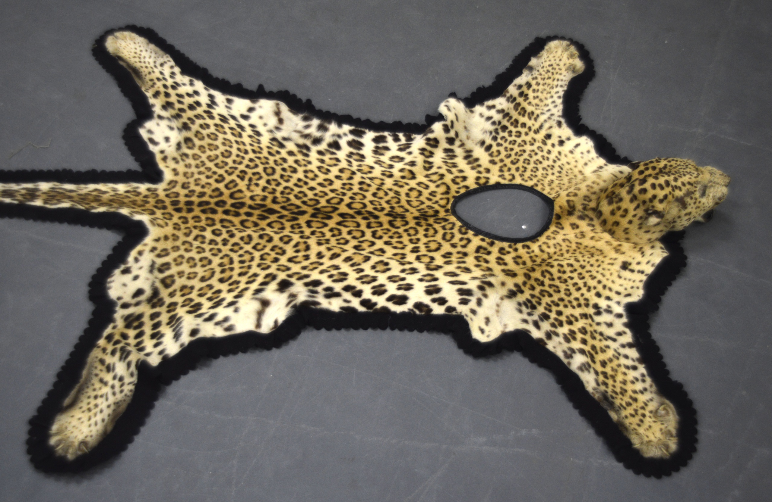 A GOOD LATE 19TH/20TH CENTURY TRIBAL LEOPARD SKIN probably used by a drummer, with hole in centre to