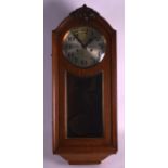 A 1930S HANGING OAK WALL CLOCK with silvered dial and black numerals. 2Ft 4ins long.