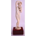A GOOD 19TH CENTURY EUROPEAN CARVED IVORY FIGURE OF A NUDE FEMALE modelled holding her braids,