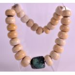 A LARGE EARLY 20TH CENTURY CARVED AFRICAN IVORY NECKLACE comprising of thick circular beads with a