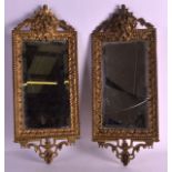 A PAIR OF 19TH CENTURY FRENCH GILT METAL MIRRORS the tops formed as portrait mask heads, within an