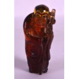 AN EARLY 20TH CENTURY CHINESE CARVED AMBER FIGURE modelled as a scholar holding a staff. 3.5ins