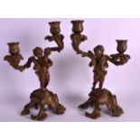 A PAIR OF 19TH CENTURY COLD PAINTED BRONZE CANDLEABRA modelled as standing cherubs holding scrolling