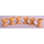 A SET OF SIX 19TH CENTURY CARVED IVORY EGG CUPS upon circular bases. 1.75ins high. (6)