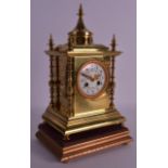 A 19TH CENTURY FRENCH BRASS EASTERN STYLE MANTEL CLOCK with folate painted dial, upon a giltwood