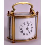 AN EARLY 20TH CENTURY FRENCH OVAL BRASS CARRIAGE CLOCK white black and gilt painted numerals. 4.