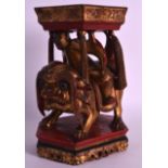 AN UNSUSUAL 19TH CENTURY POLYCHROMED CARVED WOOD GILTWOOD STAND modelled with a male upon a beast.