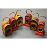 A SET OF SIX 1950S PAINTED RAILWAY LAMPS three decorated on a red pallete, the other on yellow.