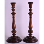 A PAIR OF EARLY 20TH CENTURY MAHOGANY CANDLESTICKS with reeded columns. 1Ft 2ins high.