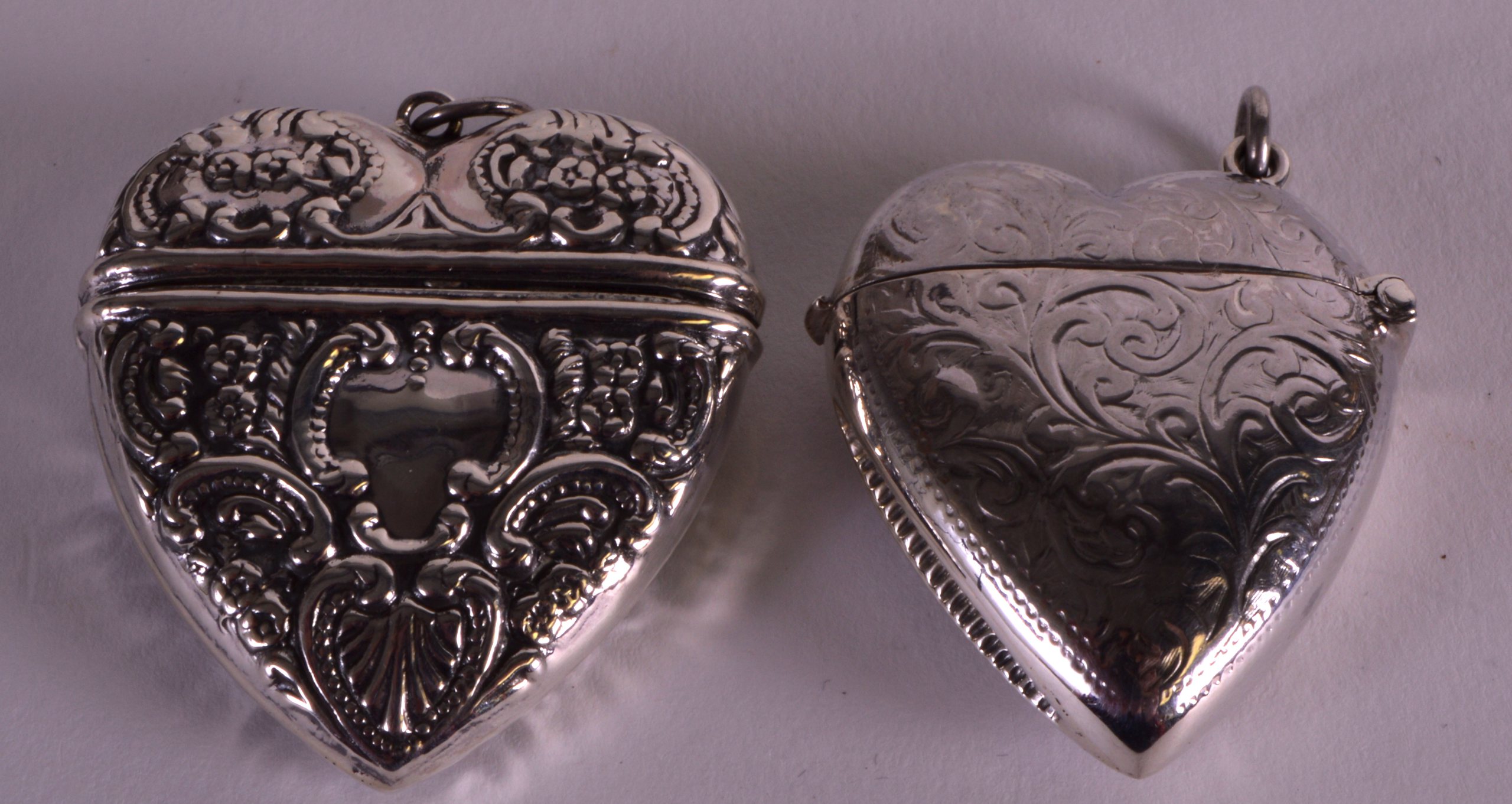 A SILVER HEART SHAPED VESTA CASE together with another similar. (2)