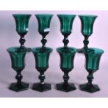 A SET OF EIGHT GEORGE III GREEN GLASSES with facetted bowls and bases. 5.5ins high. (8)