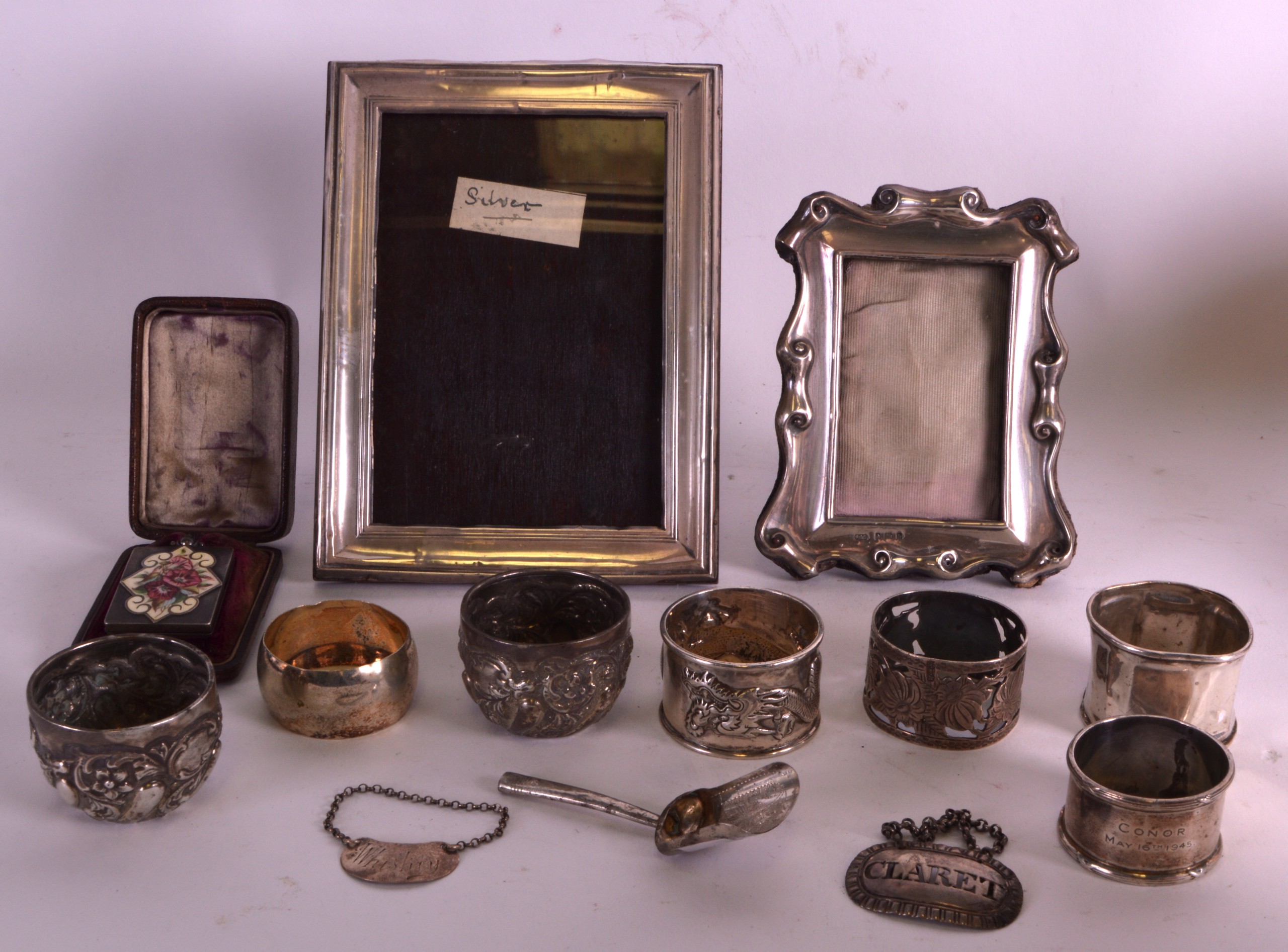 TWO EDWARDIAN SILVER PHOTOGRAPH FRAMES together with two silver wine labels, a small caddy spoons