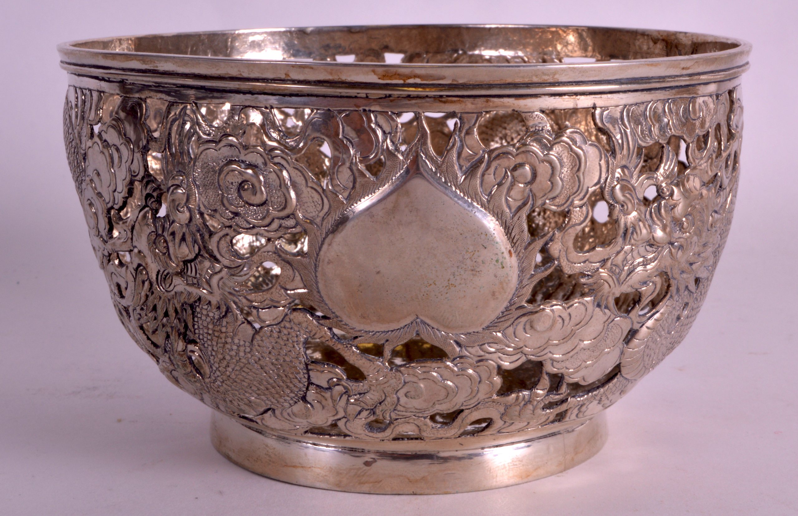 A LATE 19TH CENTURY CHINESE EXPORT PIERCED SILVER BOWL by Woshing, decorated with dragons amongst