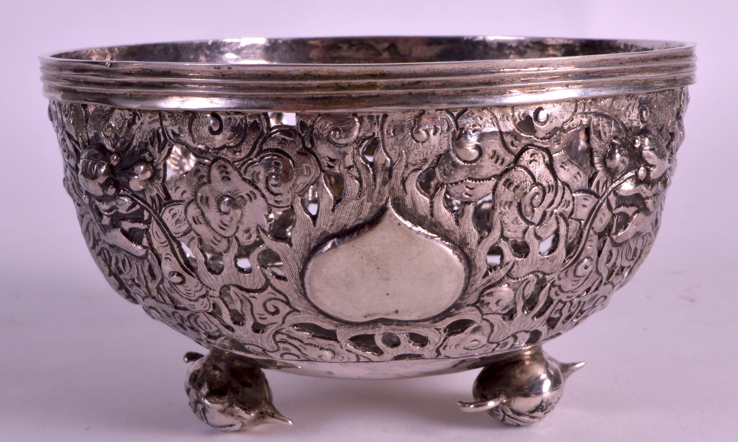 A LATE 19TH CENTURY CHINESE EXPORT SILVER BOWL decorated with dragons upon three floral feet.