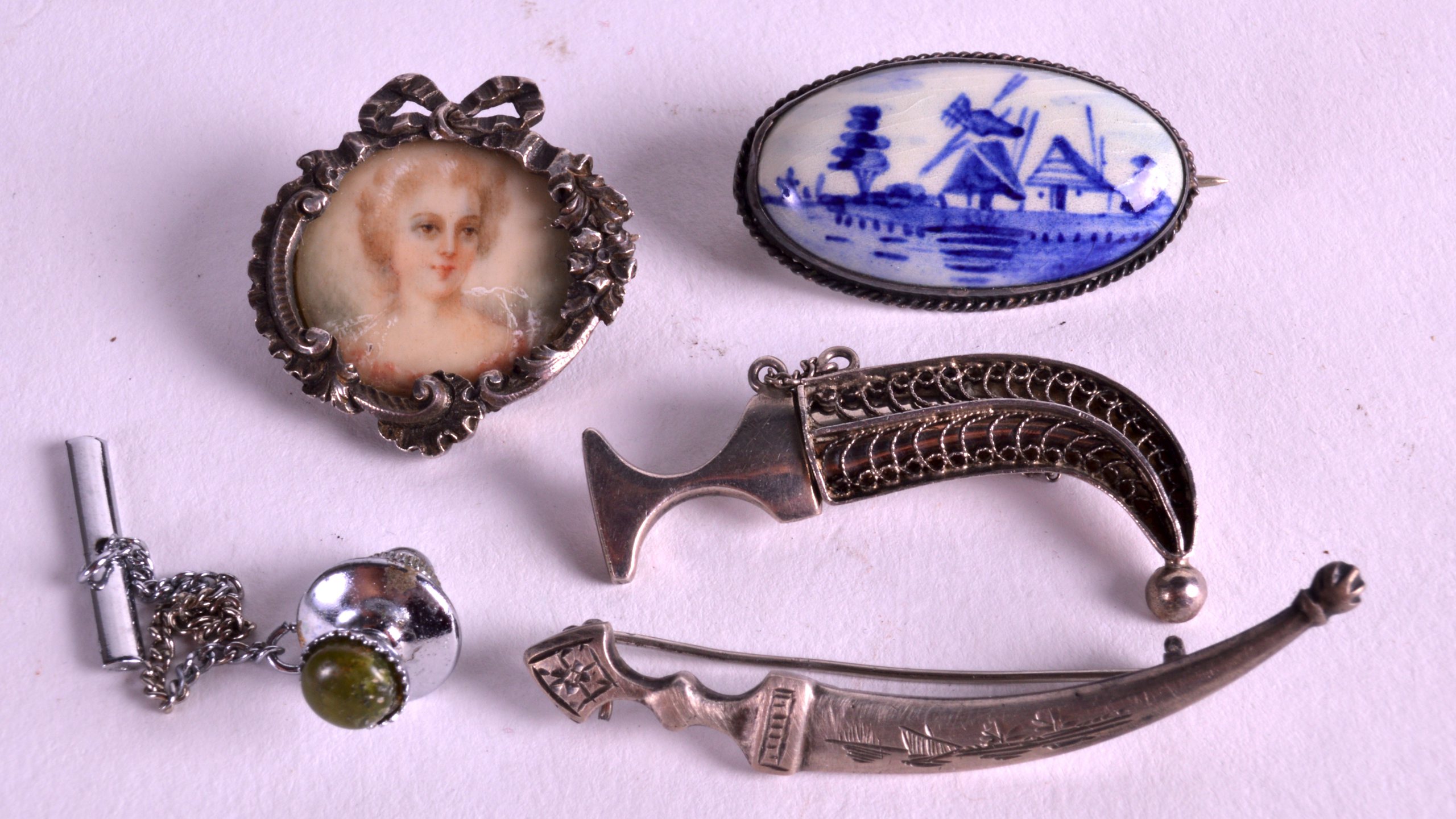 AN EDWARDIAN SILVER MOUNTED IVORY MINIATURE together with three silver brooches etc. (5)