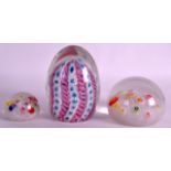 AN EARLY 20TH CENTURY ART GLASS PAPERWEIGHT together with two others. Largest 4ins high. (3)