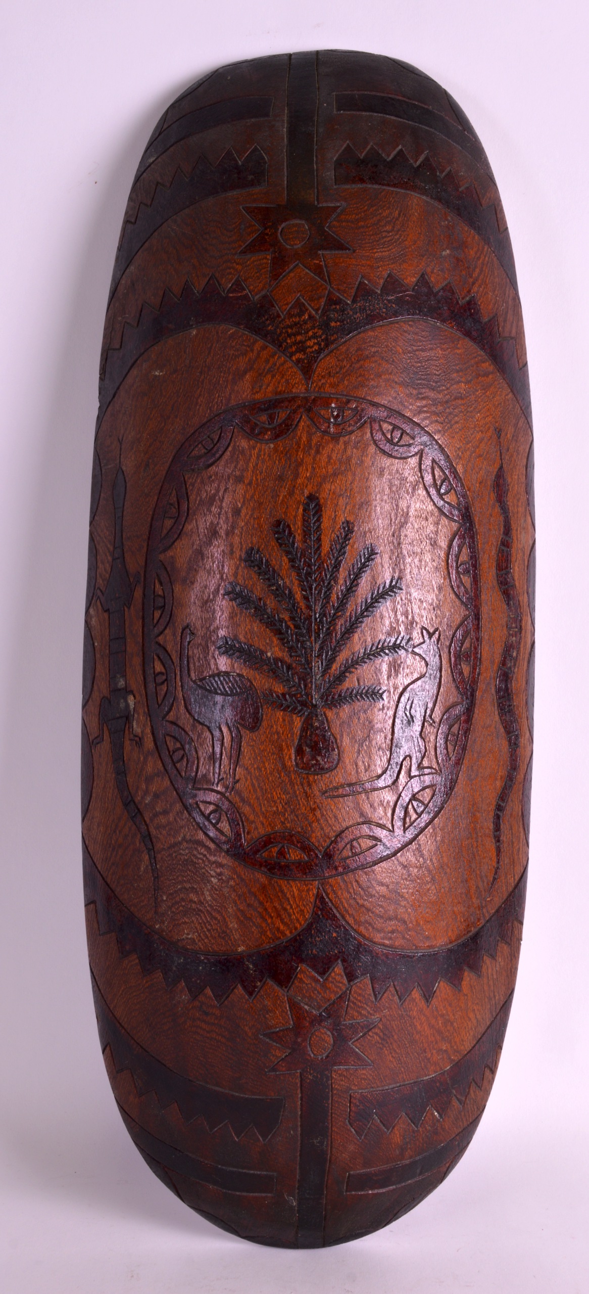 AN ABORIGINAL CARVED WOOD FACETTED SHIELD decorated all over with foliage and birds. 1Ft 11ins