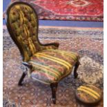 A LATE VICTORIAN CARVED WOOD UPHOLSTERED NURSING CHAIR with matching foot stool. (2)