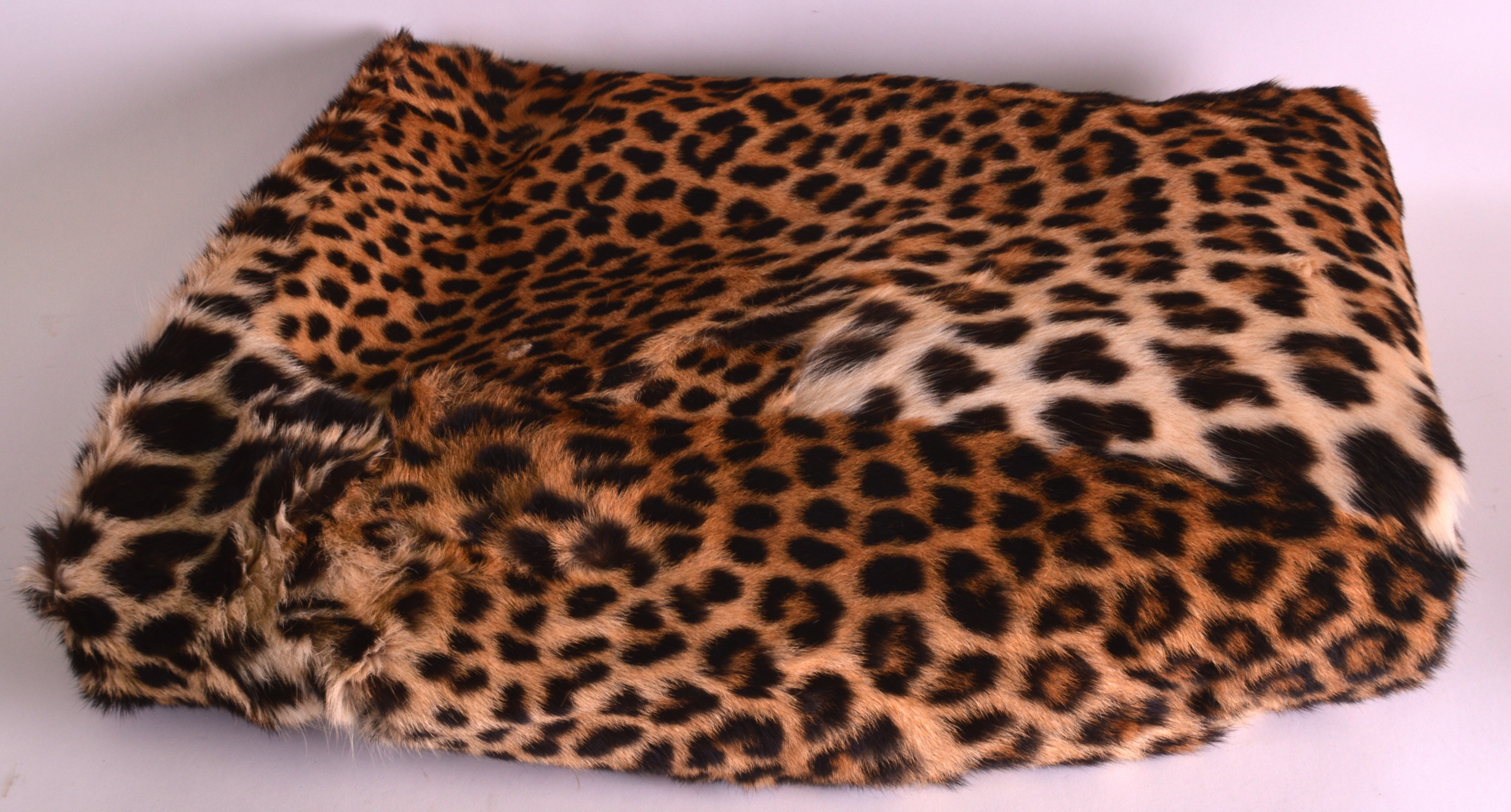 AN EARLY 20TH CENTURY LEOPARD SKIN BED COVER of naturalistic form. Provenance: Sold with a copy of