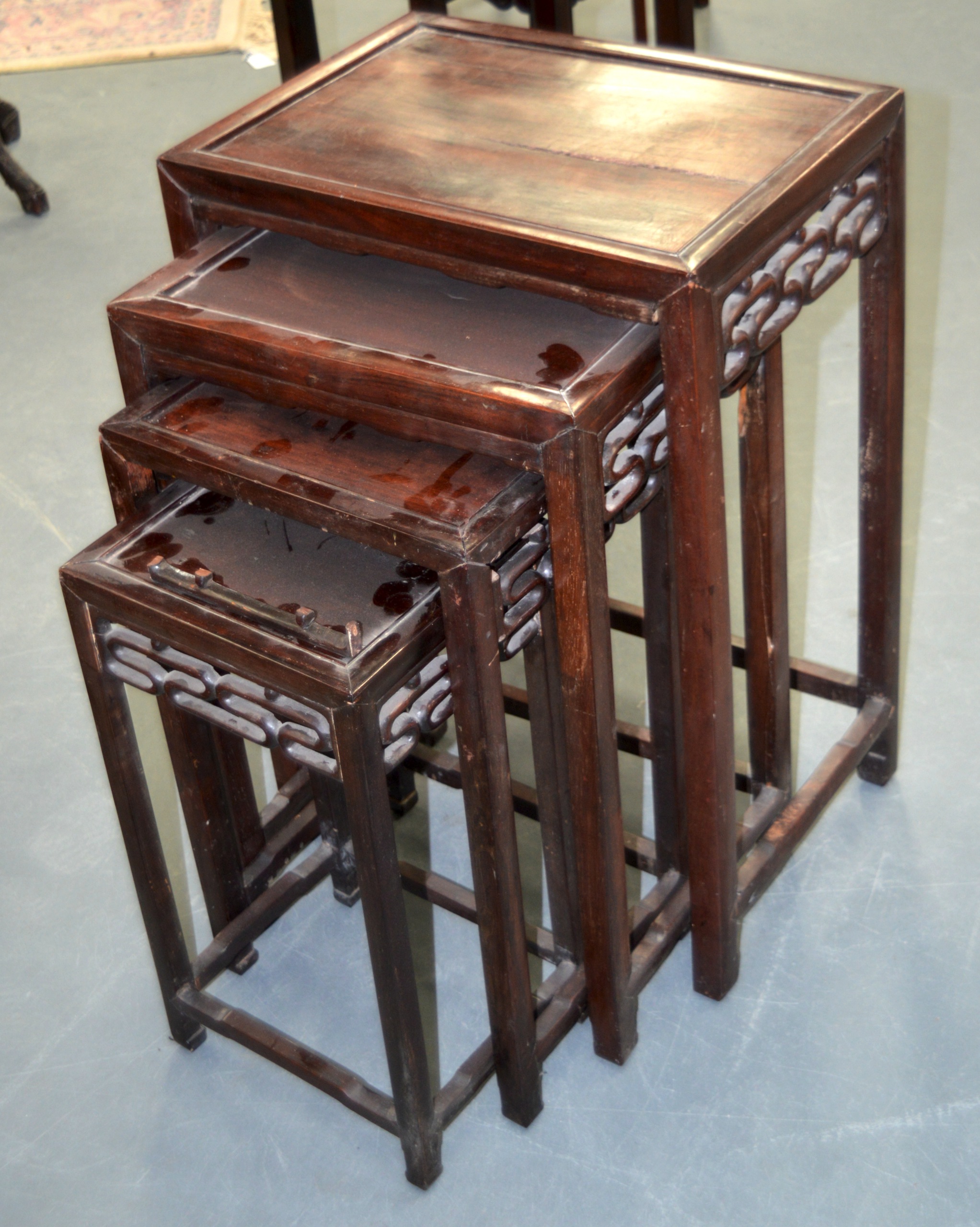 A NEST OF FOUR CHINESE CARVED HARDWOOD TABLES. Largest 2ft 4ins high. (4)