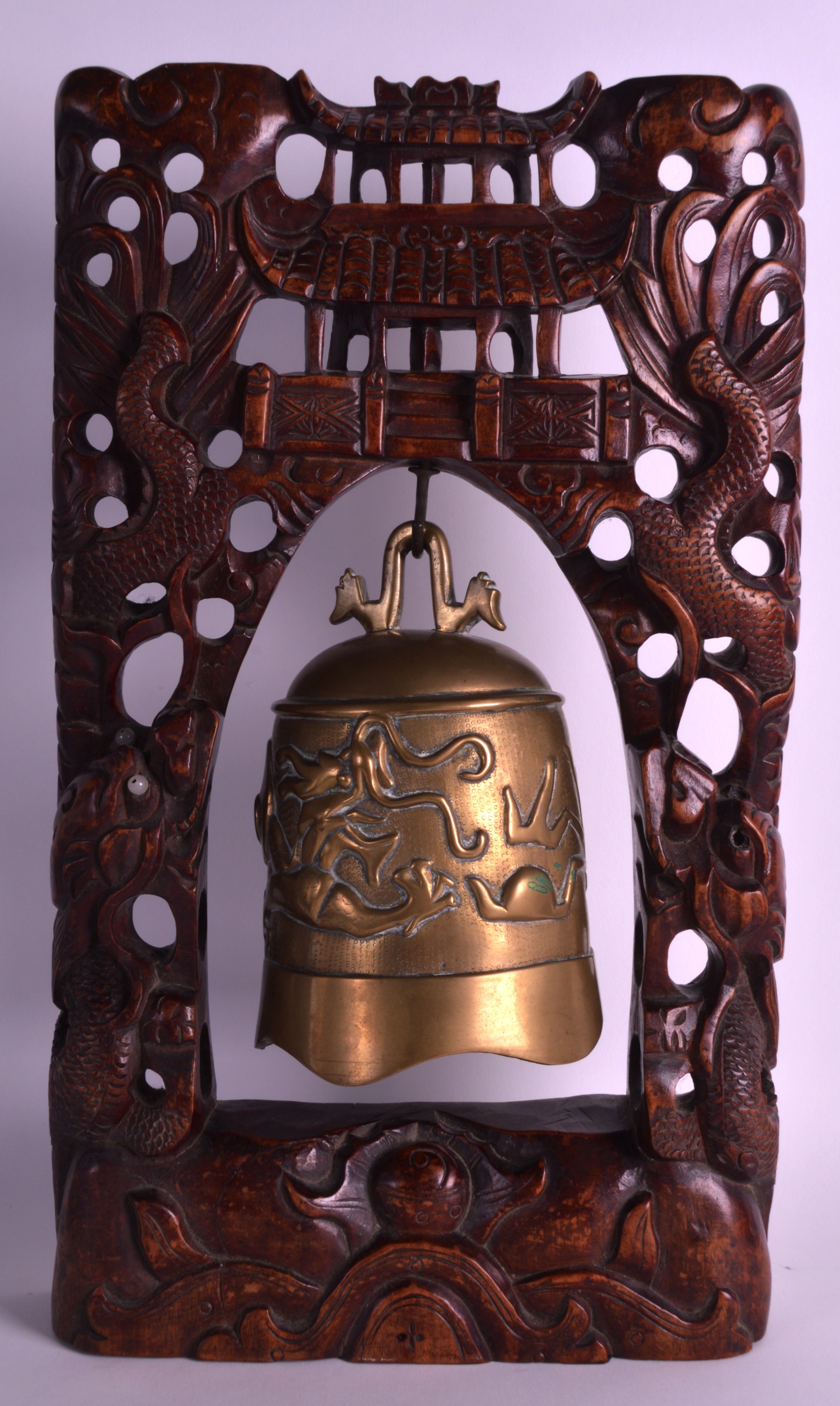 A LATE 19TH CENTURY CHINESE CARVED HARDWOOD TABLE BELL with carved dragon mounts, the bell decorated