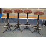 A SET OF FOUR CAST IRON UPHOLSTERED BAR STOOLS.