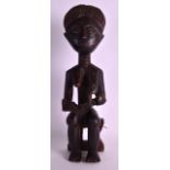 AN EARLY 20TH CENTURY CARVED AFRICAN HARDWOOD FIGURE modelled as a female breast feeding. 1Ft 4ins