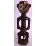 AN EARLY 20TH CENTURY AFRICAN CARVED HARDWOOD FERTILITY FIGURE modelled with exposed genitalia.