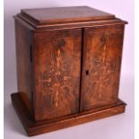 A 19TH CENTURY CARVED WALNUT DESK CABINET with two folding doors, opening to reveal three drawers.