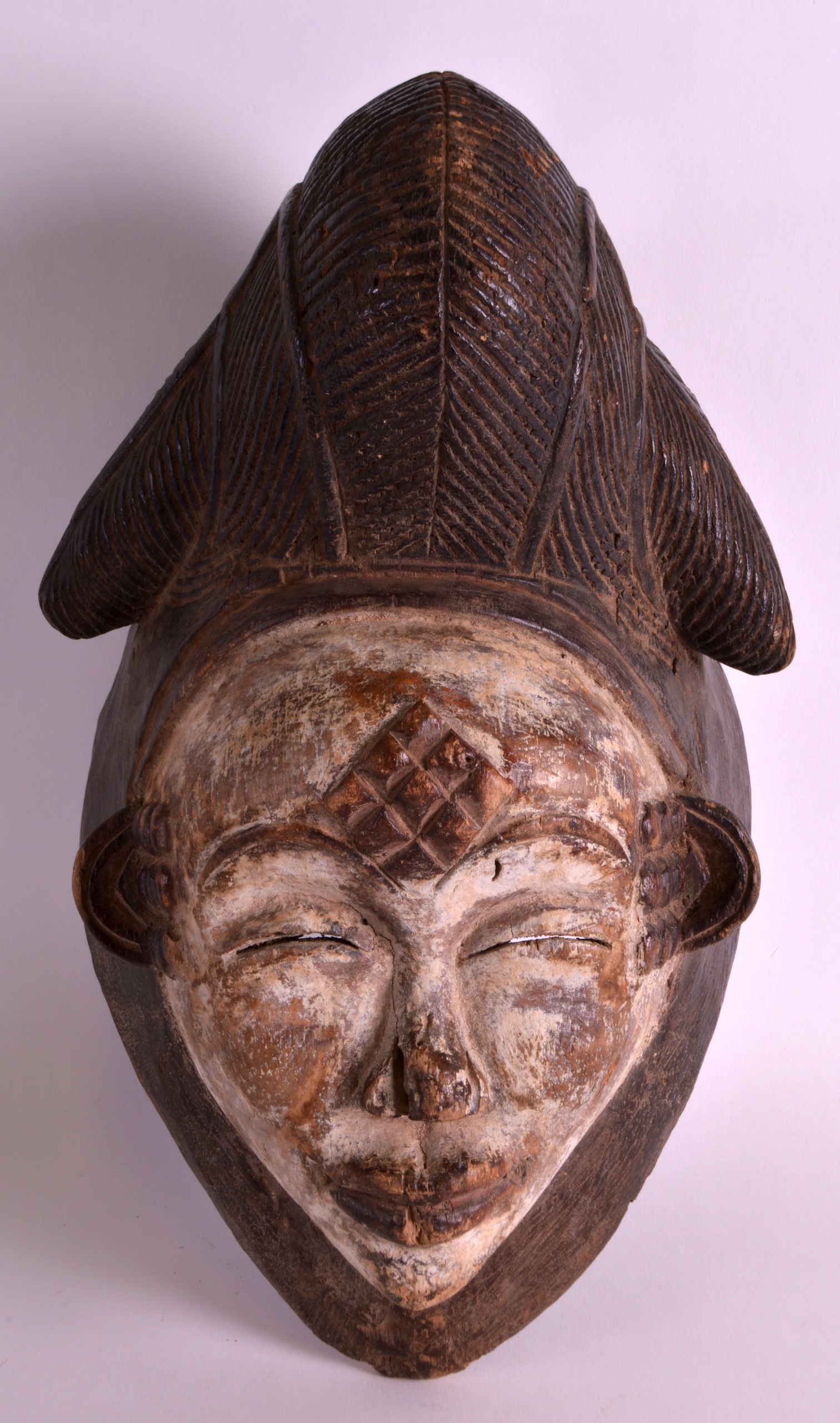 AN EARLY 20TH CENTURY CARVED AFRICAN MASK with white pigment, with angular cut features. 12Ins