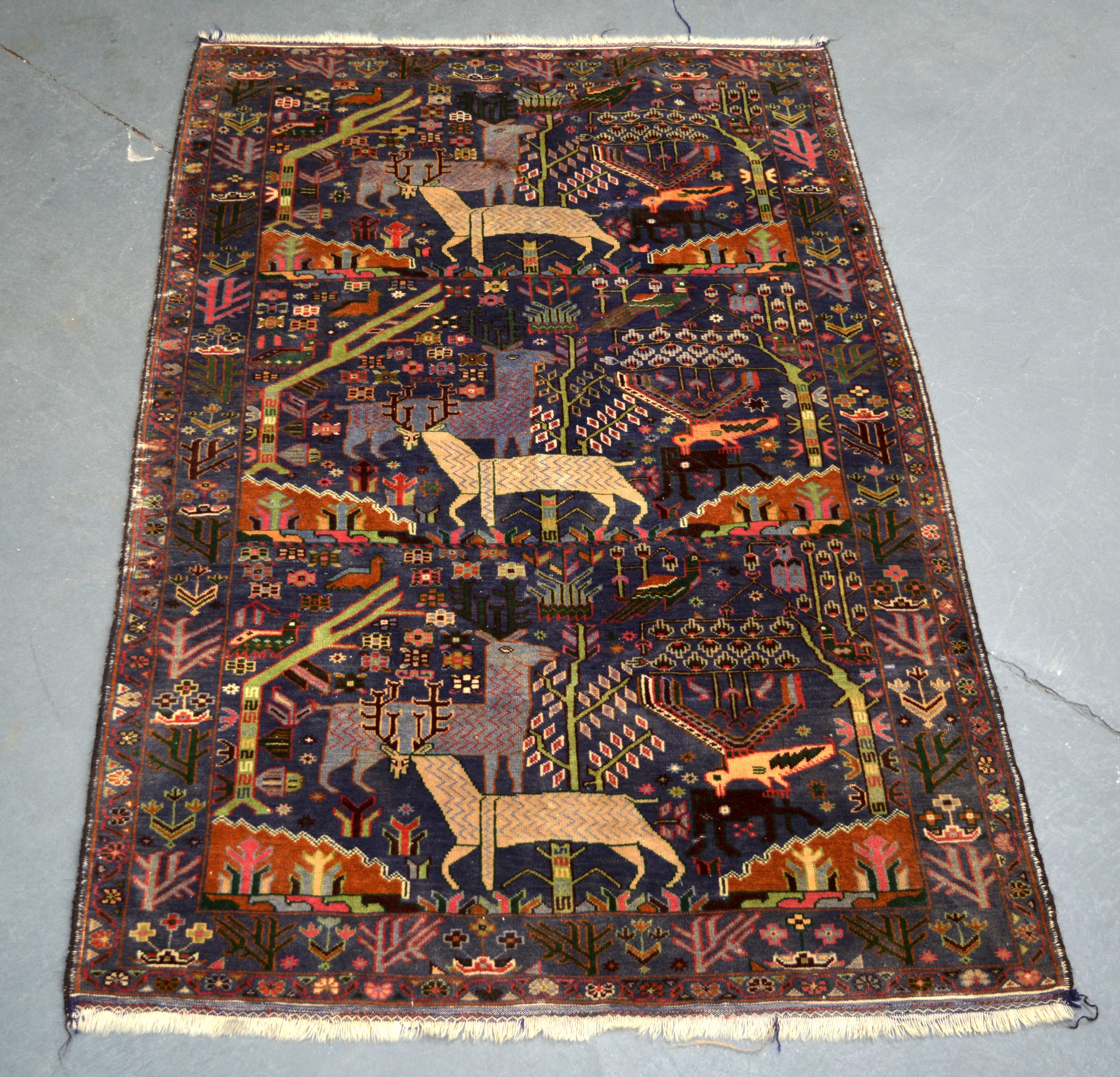 A PERSIAN PICTORIAL RUG 20th Century, depicting birds and fallow deer. 200Cm x 123cm.