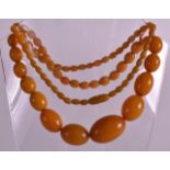 A GOOD EARLY 20TH CENTURY CARVED YELLOW BUTTERSCOTCH AMBER TYPE NECKLACE of graduated form. 54