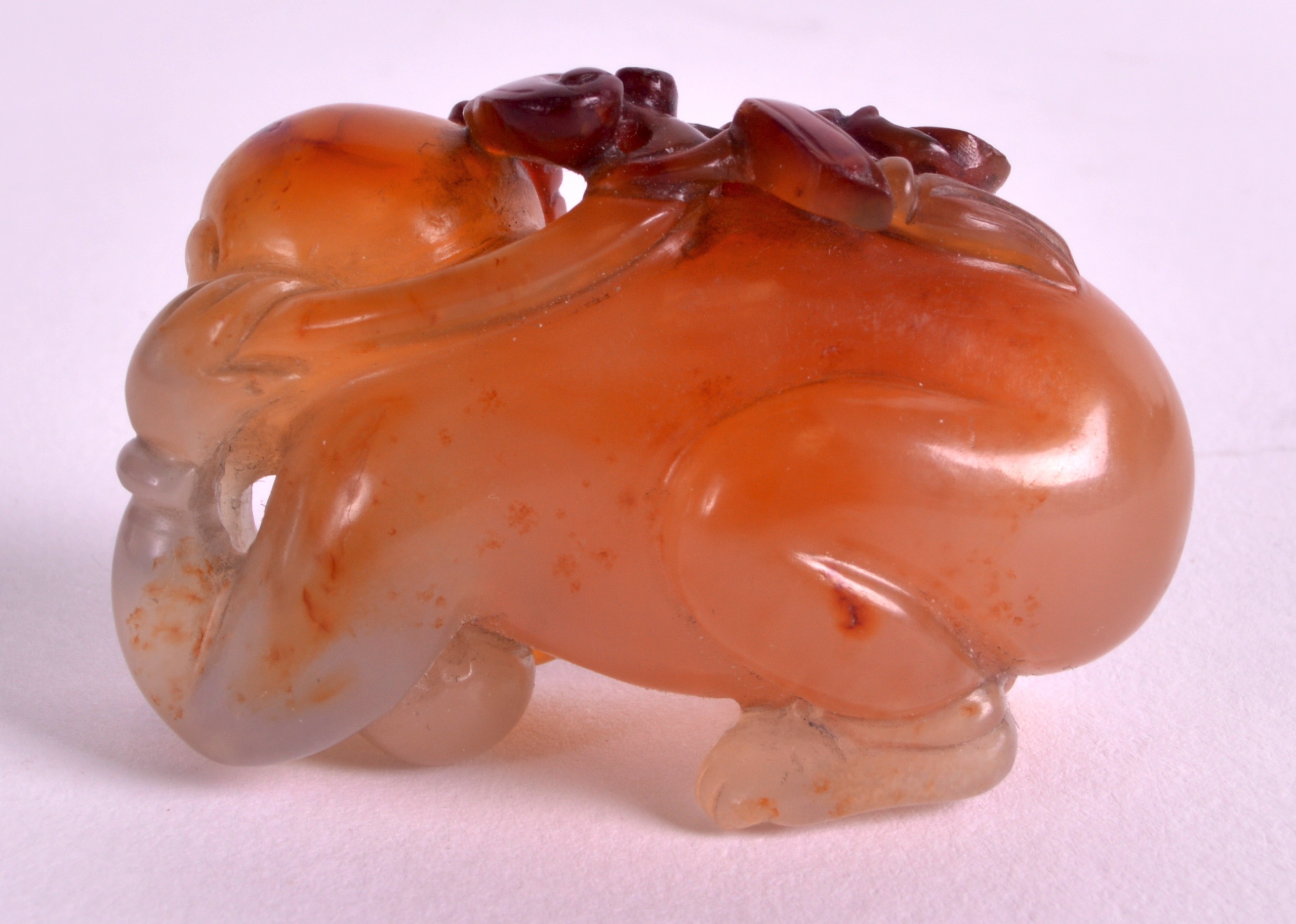 A CHINESE CARVED AGATE FIGURE OF A RECUMBANT CHILD modelled with a butterfly upon his back. 1. - Image 2 of 3