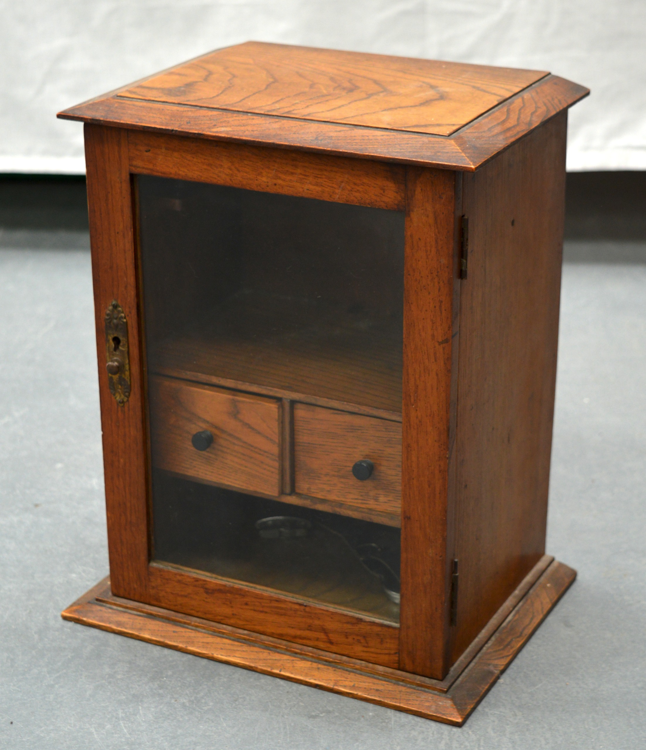 A SMALL OAK DISPLAY CABINET with two internal drawers. 1Ft 2ins x 11ins.