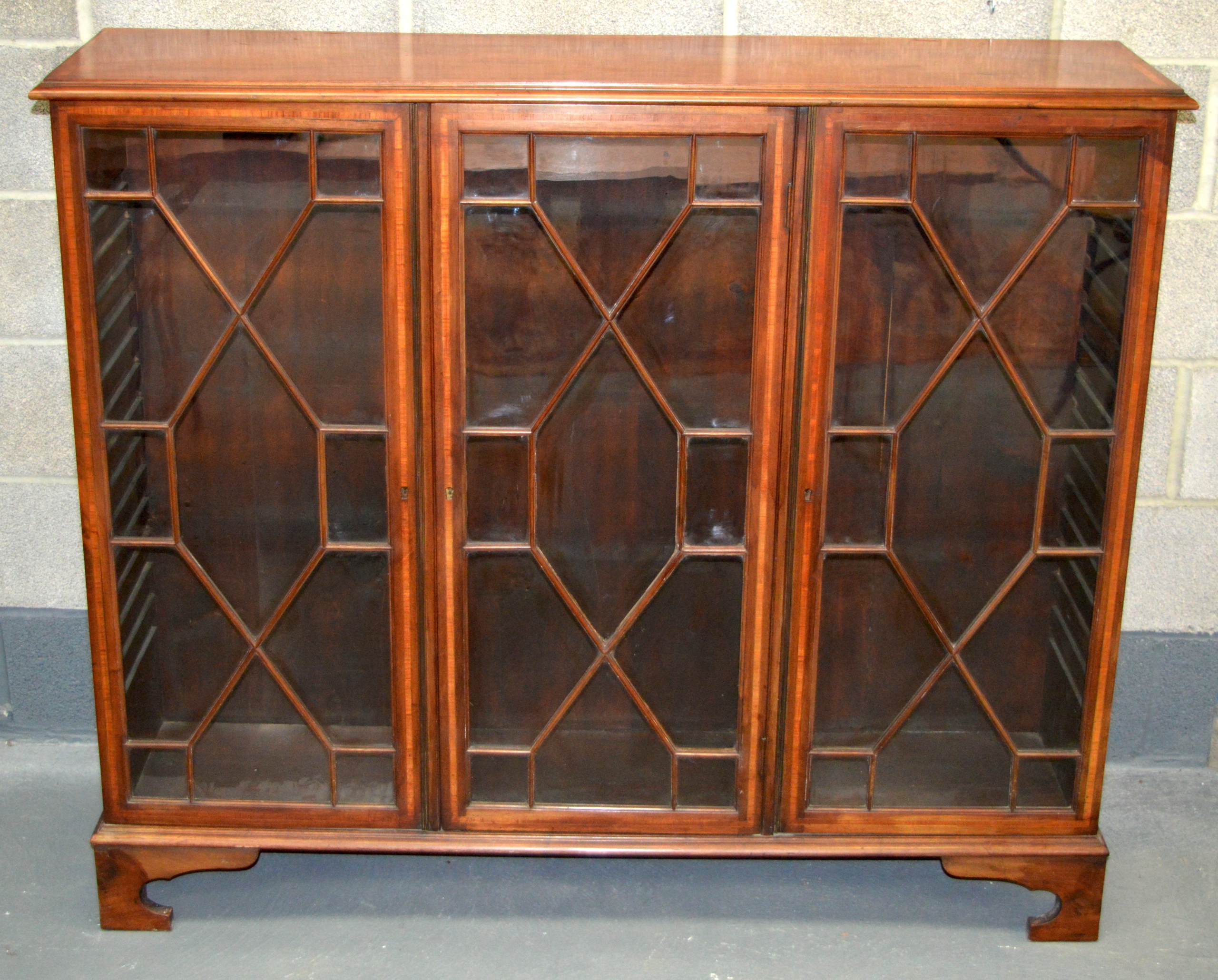 A MID 19TH CENTURY MAHOGANY BOOKCASE with triple glazed doors.