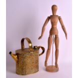 AN ARTS AND CRAFTS BRASS WATERING CAN together with a carved wood articulated doll. Can 11.5ins wide