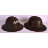 A 1940S PITH HELMET together with another similar tin helmet. (2)