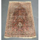 A PERSIAN SILK PRAYER RUG depicting an urn with flowers and vines. 5Ft x 3ft.