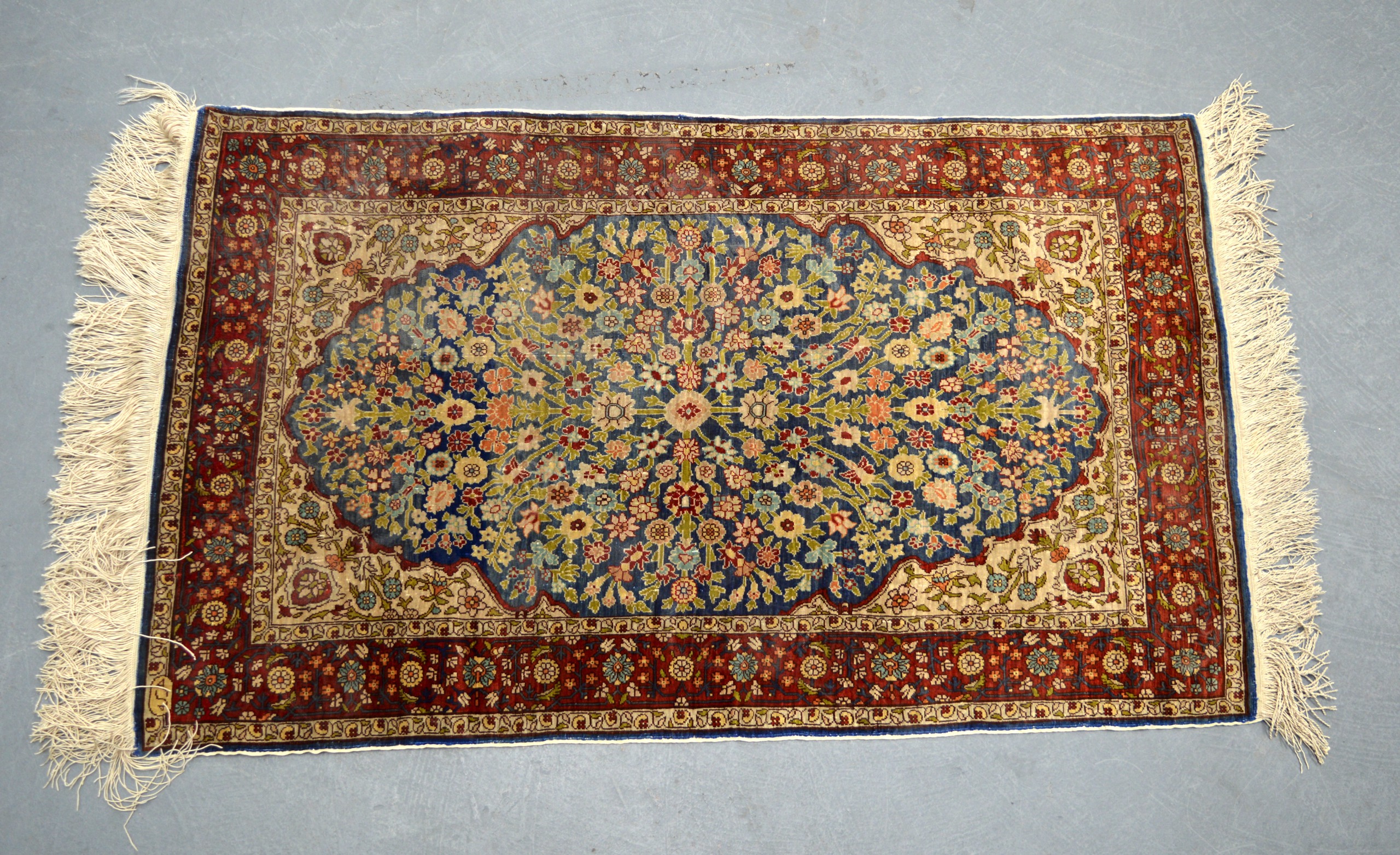 A GOOD TURKISH SILK CARPET Hereke, of small proportions, decorated with central flowers upon a