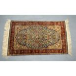 A GOOD TURKISH SILK CARPET Hereke, of small proportions, decorated with central flowers upon a