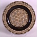 AN EASTERN MOTHER OF PEARL INLAID LACQUERED WOODEN DISH decorated with geomteric motifs. 11.5ins