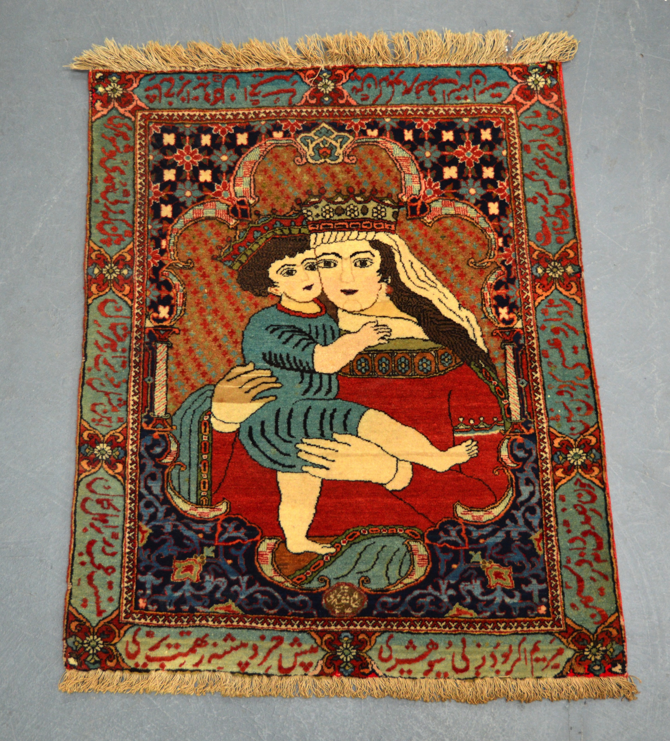 AN UNUSUAL MADONNA AND CHILD SMALL RUG within a border of Islamic symbols. 2Ft 5ins x 1ft 11ins.