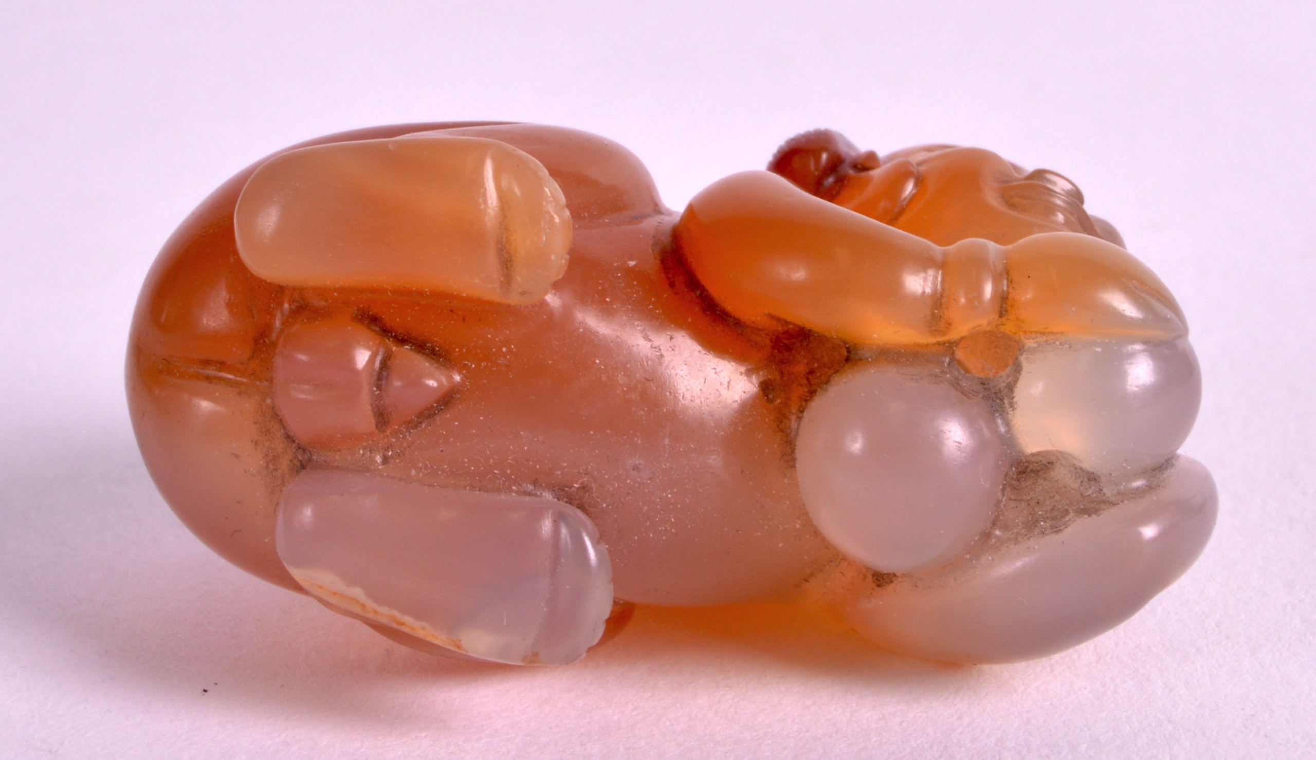 A CHINESE CARVED AGATE FIGURE OF A RECUMBANT CHILD modelled with a butterfly upon his back. 1. - Image 3 of 3