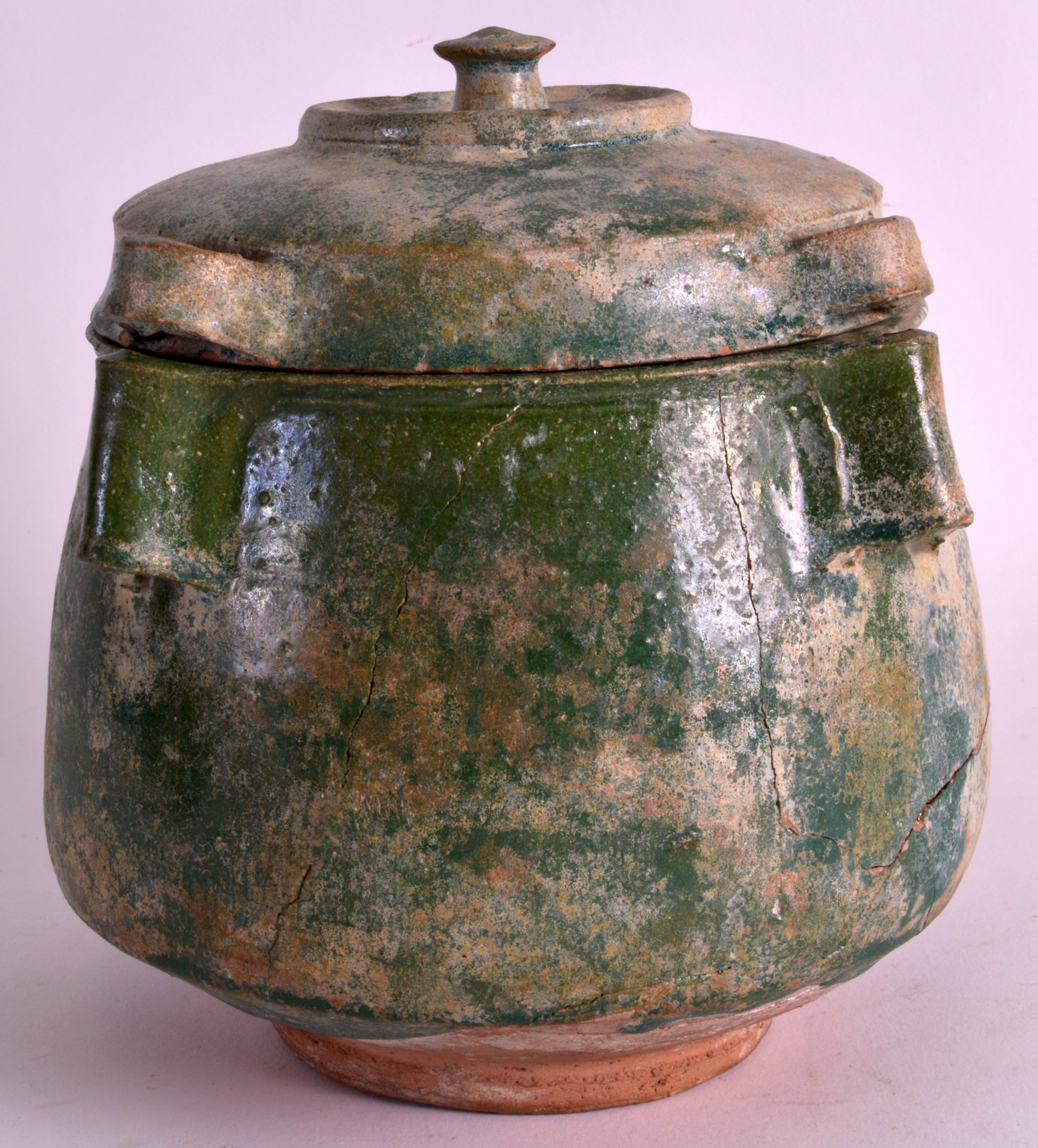 A 10TH TO 12TH CENTURY PERSIAN GREEN GLAZED POT AND COVER with four angular supports. 7.5ins high.