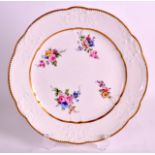 AN 18TH CENTURY SEVRES PORCELAIN MOULDED PLATE C1770 painted with flowers within a gilt border. 9.