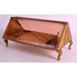 AN EARLY 20TH CENTURY FRENCH GILT METAL GLASS FRONTED JEWELLERY CASKET the pierced base surmounted