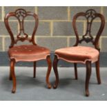 A PAIR OF VICTORIAN WALNUT SINGLE DINING CHAIRS with ruby upholstery.