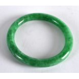 AN EARLY 20TH CENTURY CHINESE CARVED GREEN JADEITE BANGLE. 3.25ins diameter