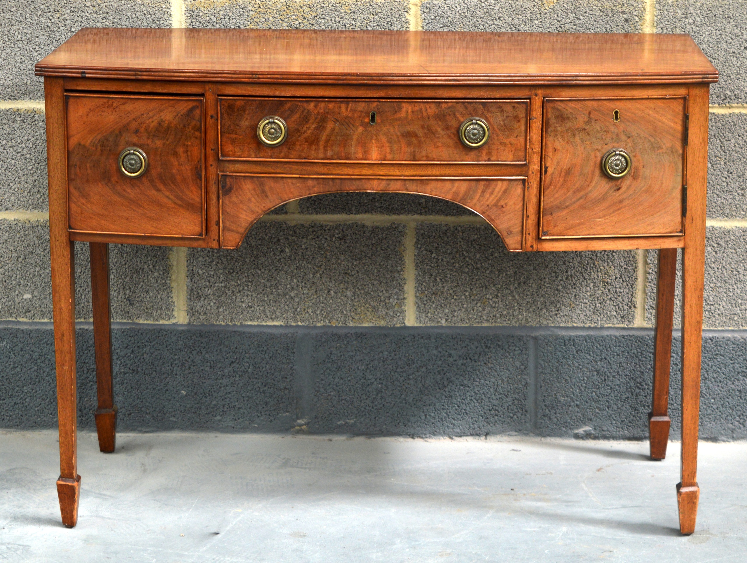 A GEORGE III MAHOGANY SERVING TABLE with single drawer flanked by two square form drawers, upon