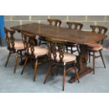 AN ERCOL DINING TABLE with six chairs. 5Ft 11ins long.